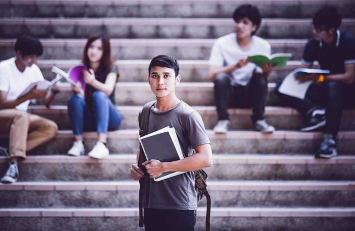 shutterstock_532421656 Student holding notebooks on campus steps