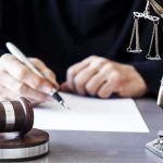 Nick Shirley Sues California Judge writing at desk with gavel and Lady Justice statue