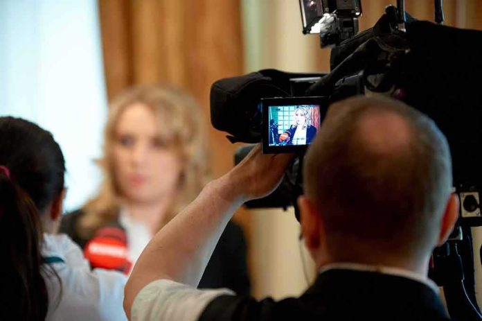 shutterstock_607357001-1 tv camera films interview with blurred speaker