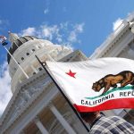 Trans Athlete’s Win Ignites Fiery Sports Debate California state flag in front of a white domed capitol building