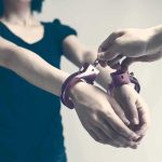 Person being handcuffed with hands extended forward