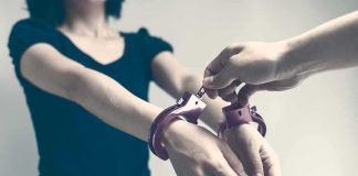 Person being handcuffed with hands extended forward