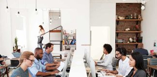 Office workers at shared desks using desktop computers