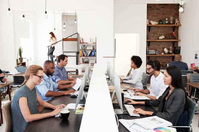shutterstock_656511280 Office workers at shared desks using desktop computers