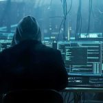 AI Hacker Models Change Cyber Arms Race hooded person at multiple computer monitors in dim room
