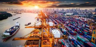 Tariff Evasion Crackdown EXPLODES Container port with cranes and cargo ships at sunset