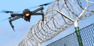 Drone flying near barbed wire security fence