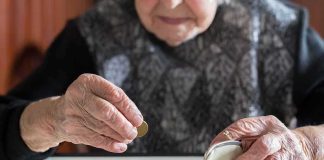 Elderly person counting coins on a table