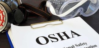 Workers Call Chinese-Owned Ohio Factory ‘UNBEARABLE’ OSHA document with safety goggles and respirator on desk