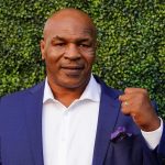 Mike Tyson Makes Bold MIDTERM Prediction at WH Mike Tyson in a blue suit raising a fist
