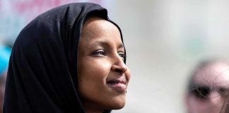 Ilhan Omar’s Bizarre BOAST on a Livestream Ilhan Omar in profile wearing a black headscarf outdoors