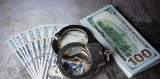 Handcuffs on US hundred-dollar bills