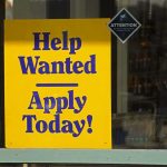 Help Wanted sign in a shop window