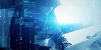 Actor/Comedian Lands on UK Counter-Terror Radar Hooded figure using a laptop with digital code overlay