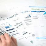 Hands reviewing utility bills with calculator and pen