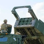 Why Army TOMAHAWKS Are Now in Europe Soldier beside a military rocket launcher vehicle
