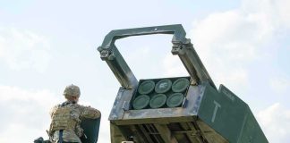 Soldier beside a military rocket launcher vehicle