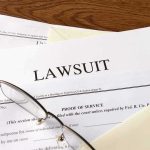 Epstein’s Money Men Sued Over His CRIMES Legal documents labeled lawsuit on a desk