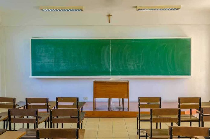 shutterstock_343131818 Empty classroom with green chalkboard and wooden desks