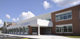 Hero Who Stopped School Shooter Now HAUNTED Modern school building with large windows and a clear sky